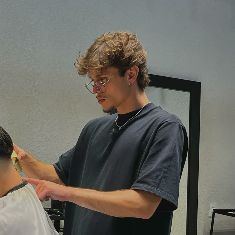 João Varella cortando o cabelo de um cliente